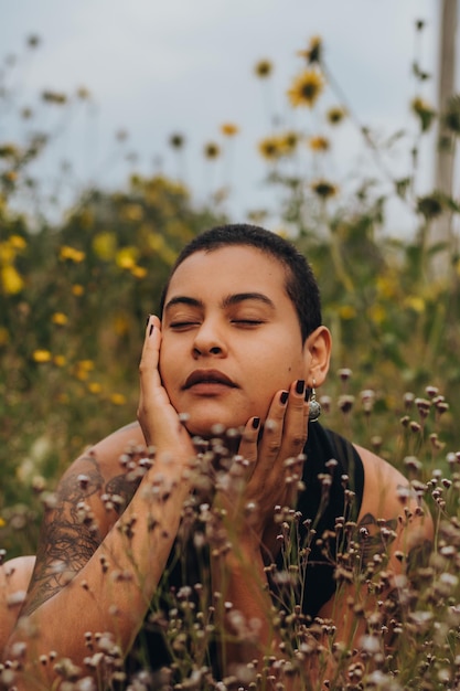 Happy young shorthaired woman with AfroLatin features Portrait of a woman surrounded by flowers wearing summer clothes enjoying nature