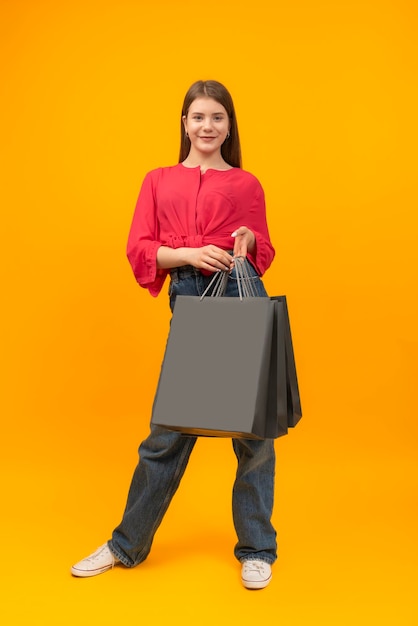 Happy young smiling woman after shopping with large paper bags Black Friday shopping Mock up Vertical frame