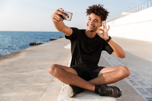 Happy young sportsman at the beach