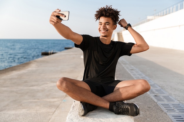 Happy young sportsman at the beach