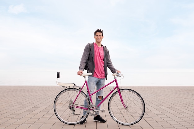 Happy young student smiling and holding a bike