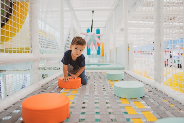 Happy young toddler boy playing in the indoor play area