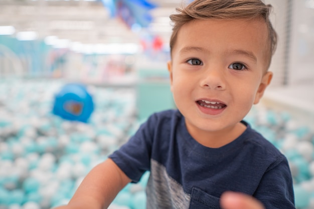 Happy young toddler boy playing in the indoor play area