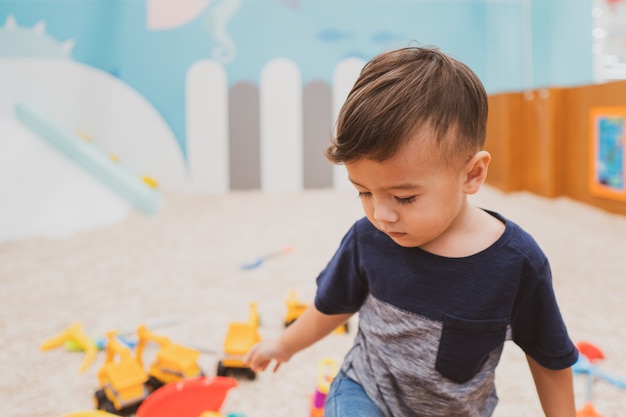 Happy young toddler boy playing in the indoor play area