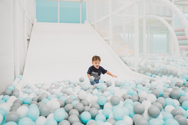 Happy young toddler boy playing in the indoor play area