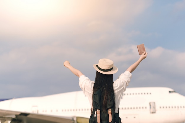 Happy young tourist at airport with a passport to catch a plane.freedom and active lifestyle concept