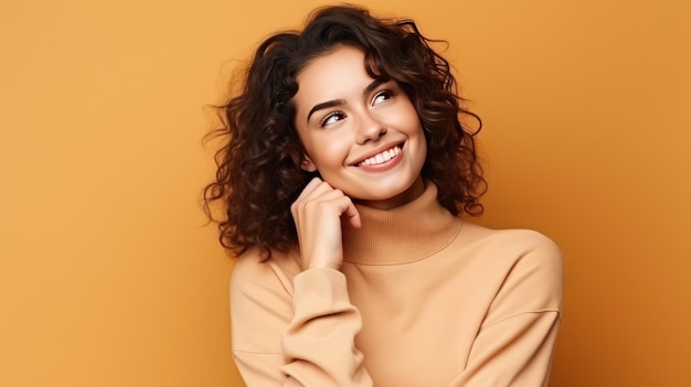 happy young woman in beige sweater looking away isolated on yellow background