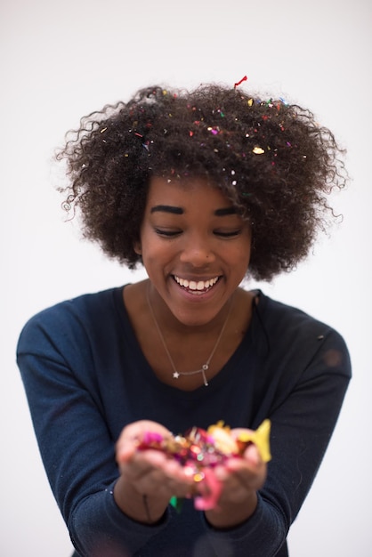 happy young woman celebrating new years eve party while blowing confetti