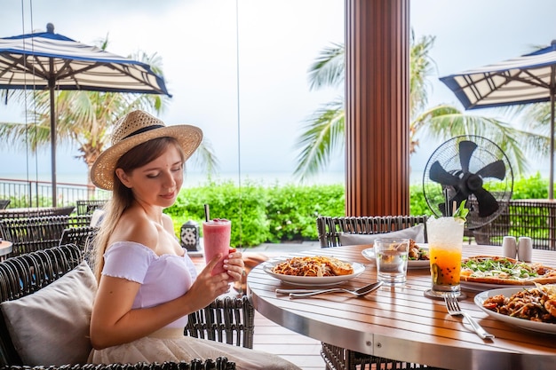 Happy young woman eating italian pasta in restaurant female with food in cafe