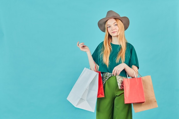 Happy young woman holding shopping bags staying Pretty girl walk shopping center carry many packs