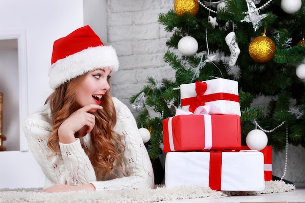 Happy young woman lying on the floor with christmas gift box