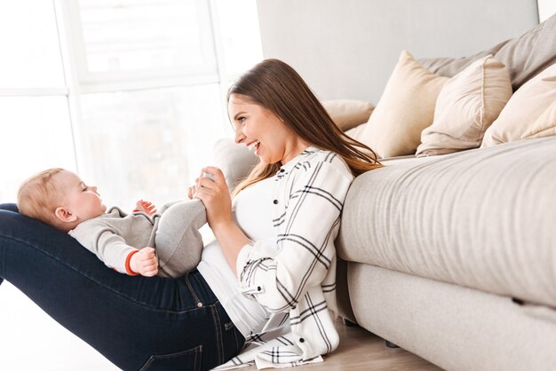 Happy young woman mother having fun with her little son