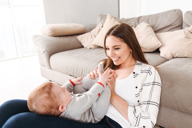 Happy young woman mother having fun with her little son