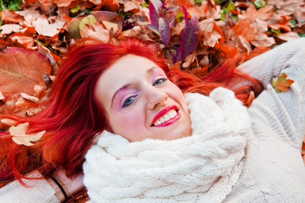 Happy young woman in park on sunny autumn day.