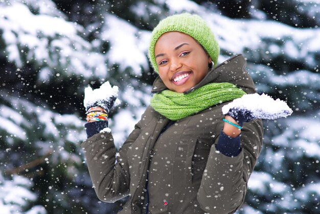 Happy young woman play with snow at winter cold day