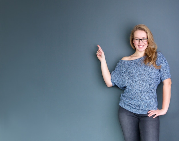 Happy young woman pointing