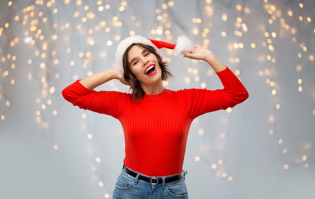 Photo happy young woman in santa hat on christmas