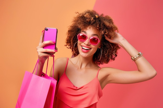 Photo happy young woman shopping and taking a selfie with smartphone carrying bags in city streets