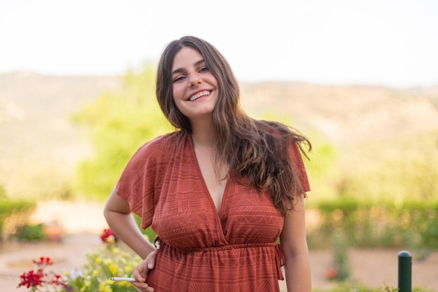 Happy young woman smoking in the countryside