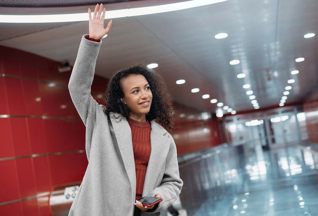 Happy young woman standing on the subway platform