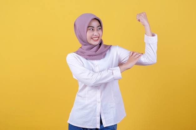 Happy young woman standing with her head showing spirit and strong wearing hijab