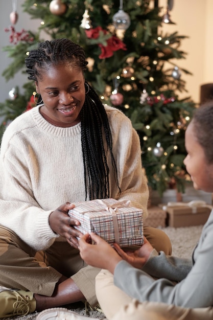 Happy young woman taking xmas gift of her daughter