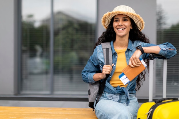 Happy young woman travelling alone looking at copy space