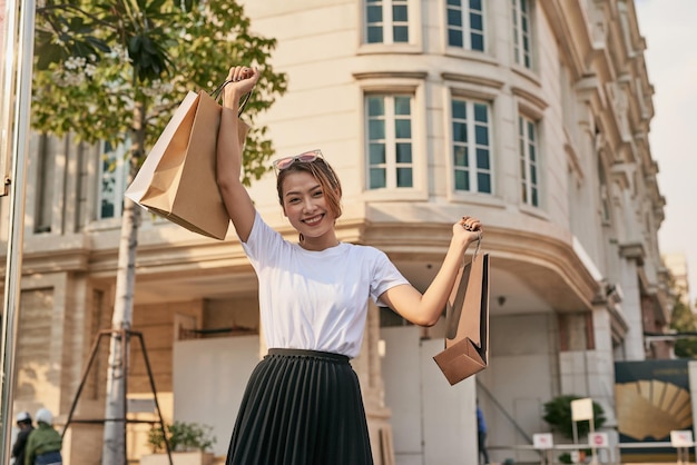 Happy young woman walking after shopping on mall sale