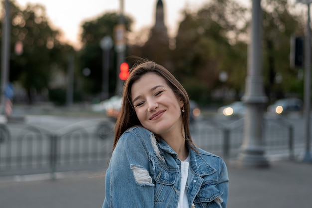 Happy young woman walking on the city and smiling. Portrait of beautiful student girl. Evening walk.