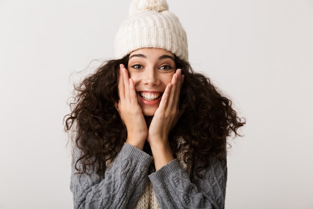 Happy young woman wearing winter clothes standing isolated over white wall