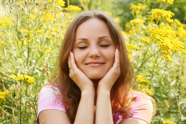 Happy young woman and wild flowers.