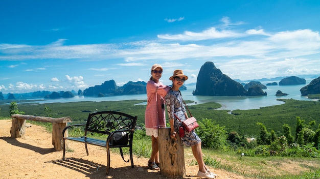 Happy young women enjoying valley view from top of a mountain