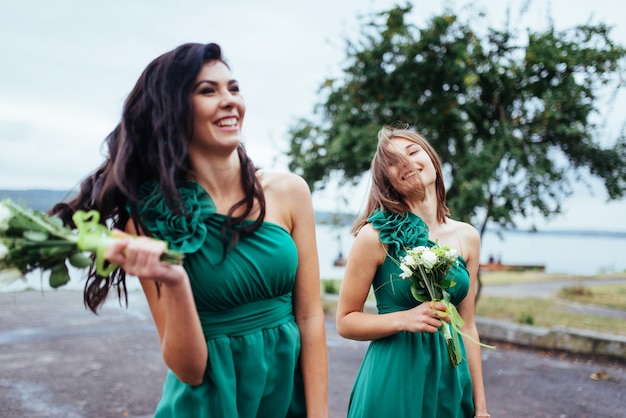 Photo happy young women at a wedding with bouquets of flowerrs