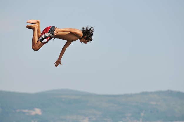 Photo happyfriend  boys group have fun and jump in sea at summer vacation