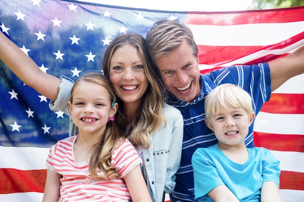 Hapy family holding american flag in the park