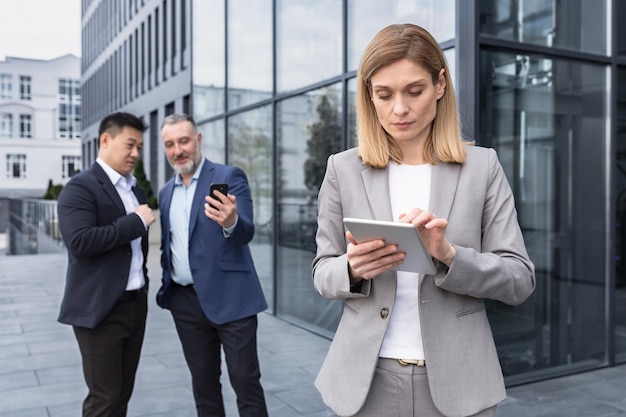 Harassment and stalking bullying in the office business people colleagues men making fun of a woman