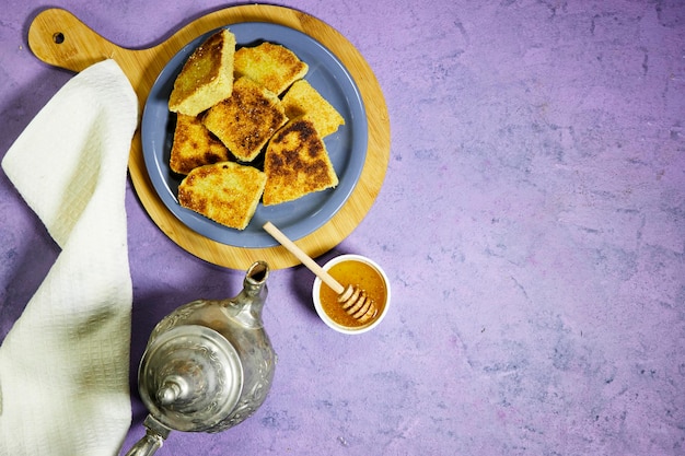 harcha or mbasses semolina algerian pancakes on an arabesque colorful plate above cutting board