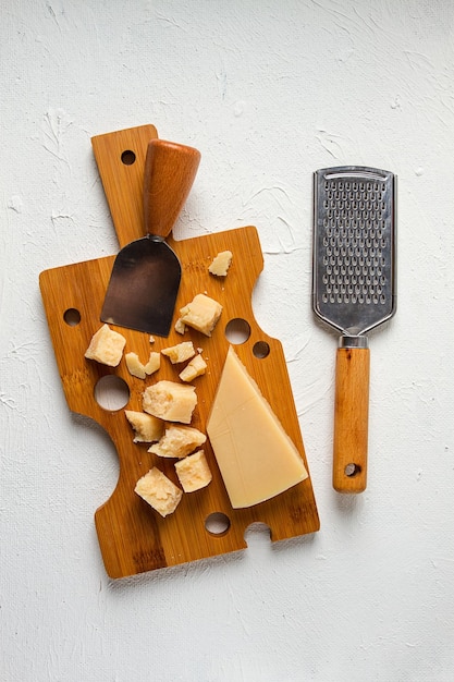 Hard cheese parmesan on a cutting board cheese knife grater top view no people