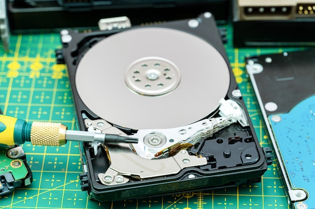 Hard disk drive disassembling process with screwdriver in information recovery, repair HDD service