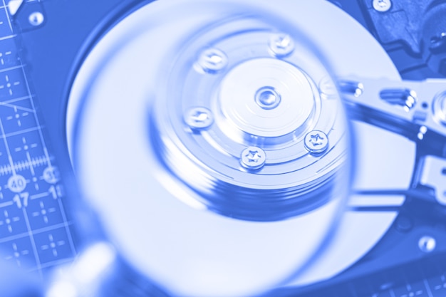 Hard disk drive through a magnifying glass, information search, diagnostics, restore