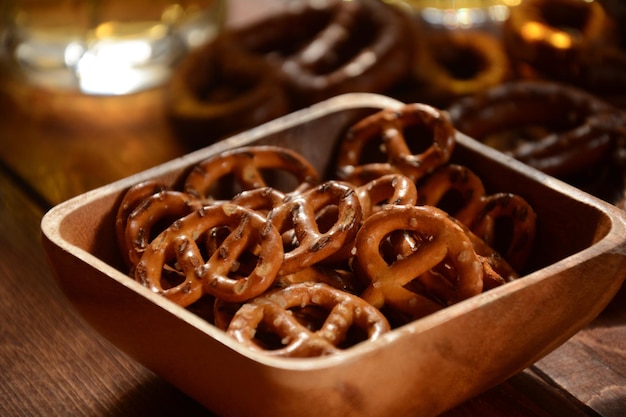 Hard Pretzels or Salted pretzels snack for party on rustic wooden table with glass of beer