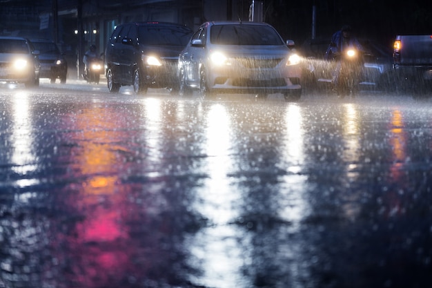 Hard rain fall at night with blurry cars .Selective focus.