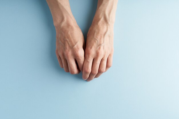 Hard-working hands with protruding veins on blue.