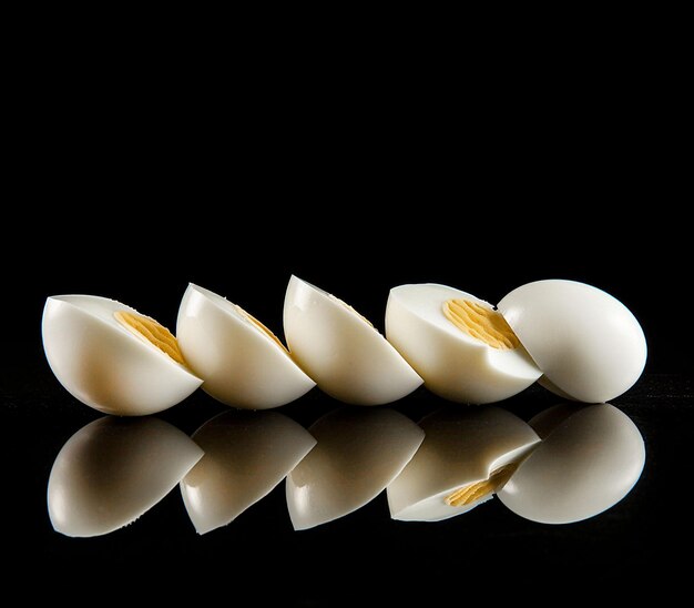 Hardboiled and halved eggs on a black background generated ai