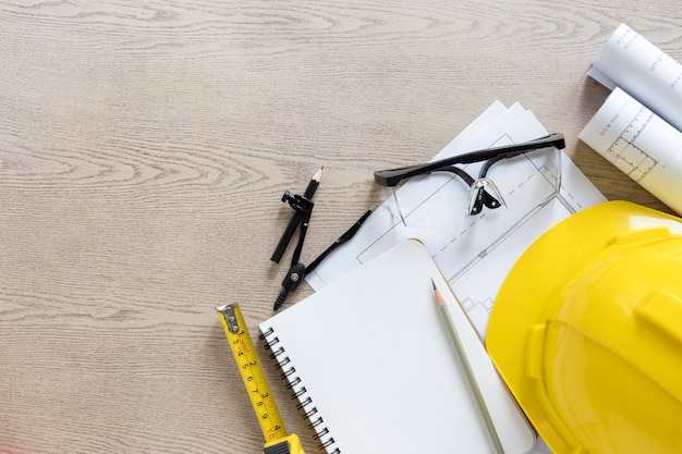 Hardhat and drafting supplies on wooden tabletop