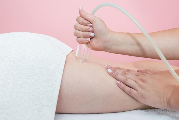 Hardware cosmetology Vacuum massage procedure in a medical beauty center Closeup of a young woman's anticellulite cupping therapy