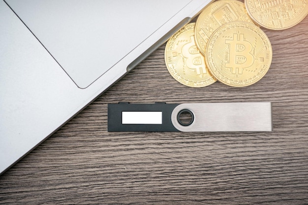 Hardware cryptocurrency wallet with golden Bitcoin BTC and computer Safe storage for crypto