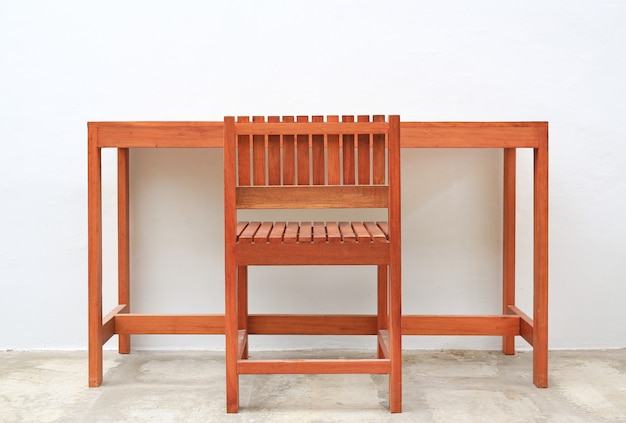 Photo hardwood furniture, indoor wooden chair and table set against white cement wall background.