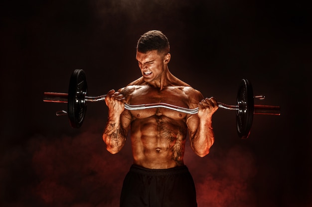 Hardy man doing exercise with heavy bar