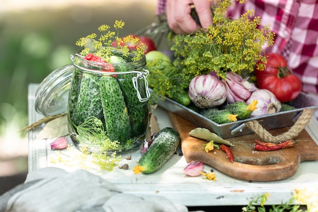 Harvest cucumbers. Fresh cucumbers in a glass jar, herbs and spices for pickling.